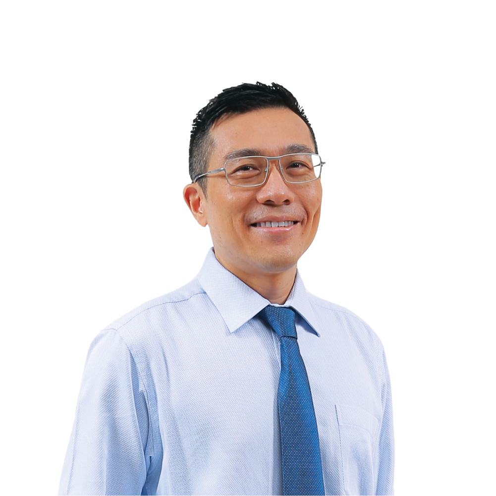 Man in glasses, blue shirt, and tie, hand in pocket. He wears black shoes.